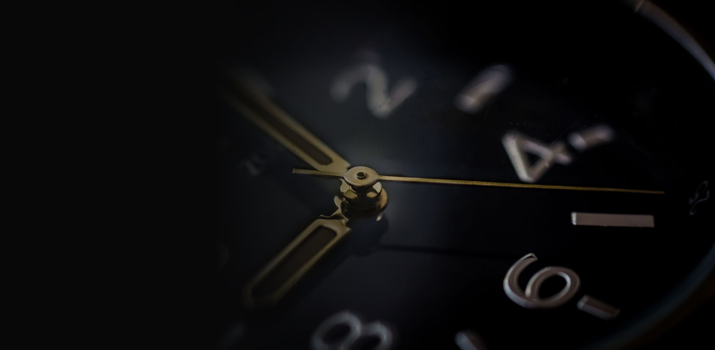 Gros plan d'un cadran de montre noir aux aiguilles dorées
